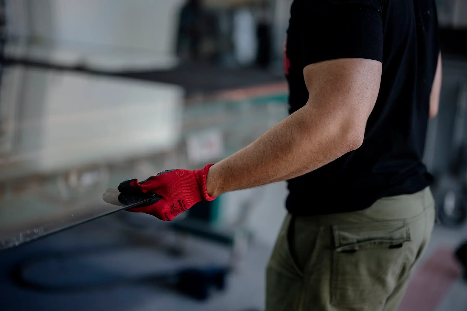 Kesilmiş metal levhayı tutan eldivenli el